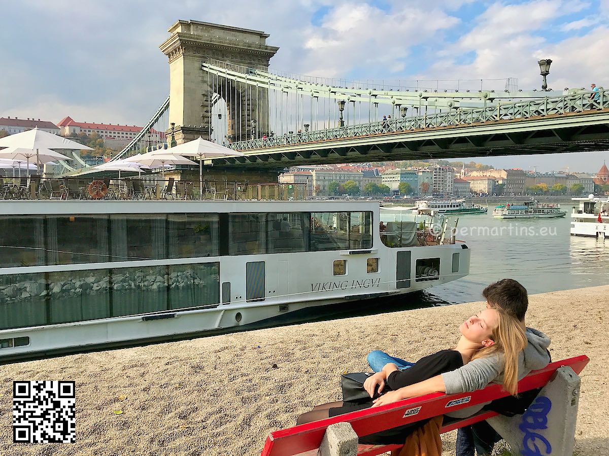 Hungary Budapest a romatic couple on a bench near the Chain bridge Szechenyi over Danube Donau