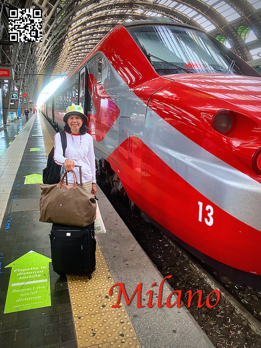 Italy Milano Centrale woman with luggage next to a red train at the station