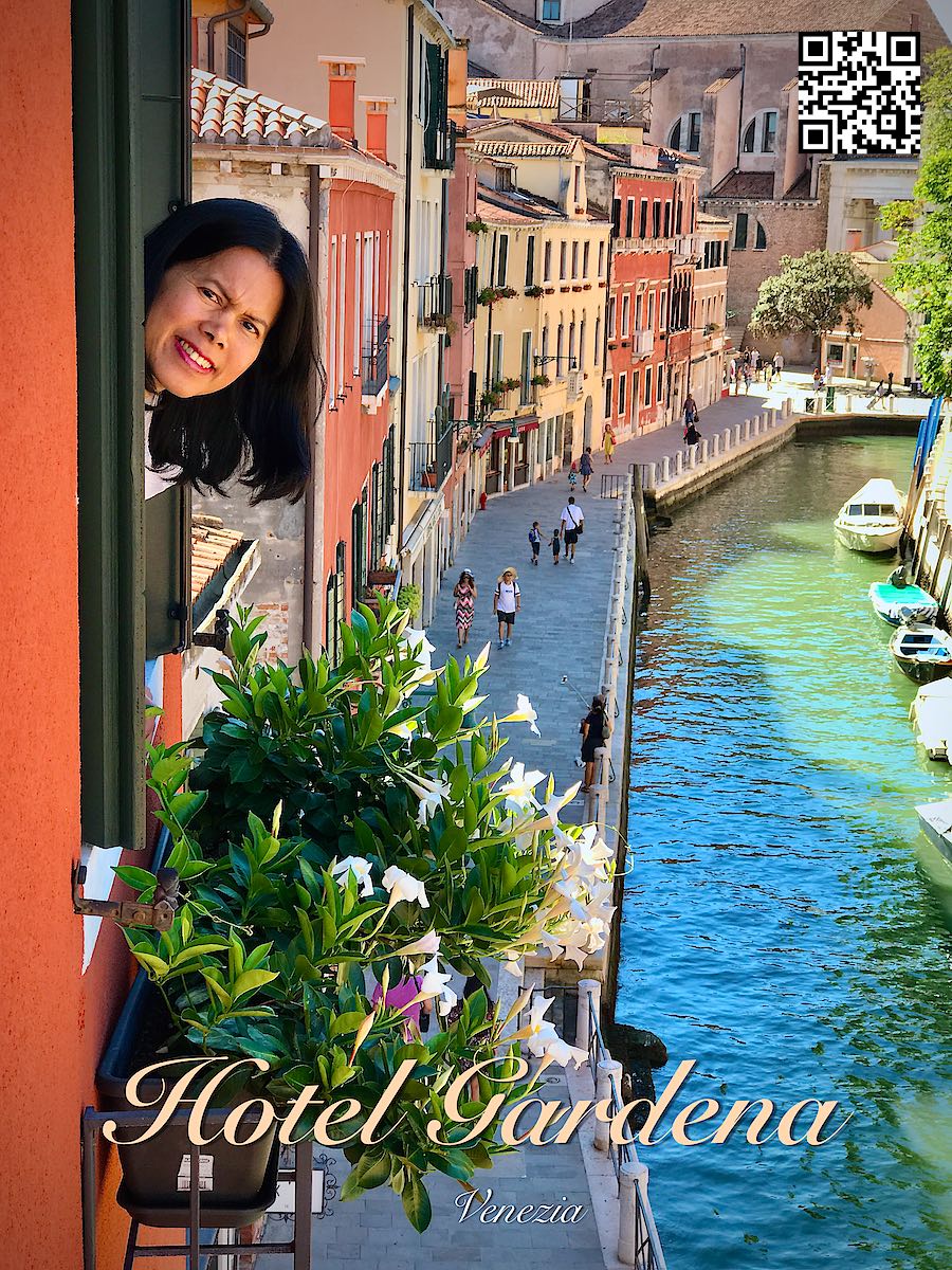 Italy Venice women sticking out her head from a window at Hotel Gardena view over a canal behind her